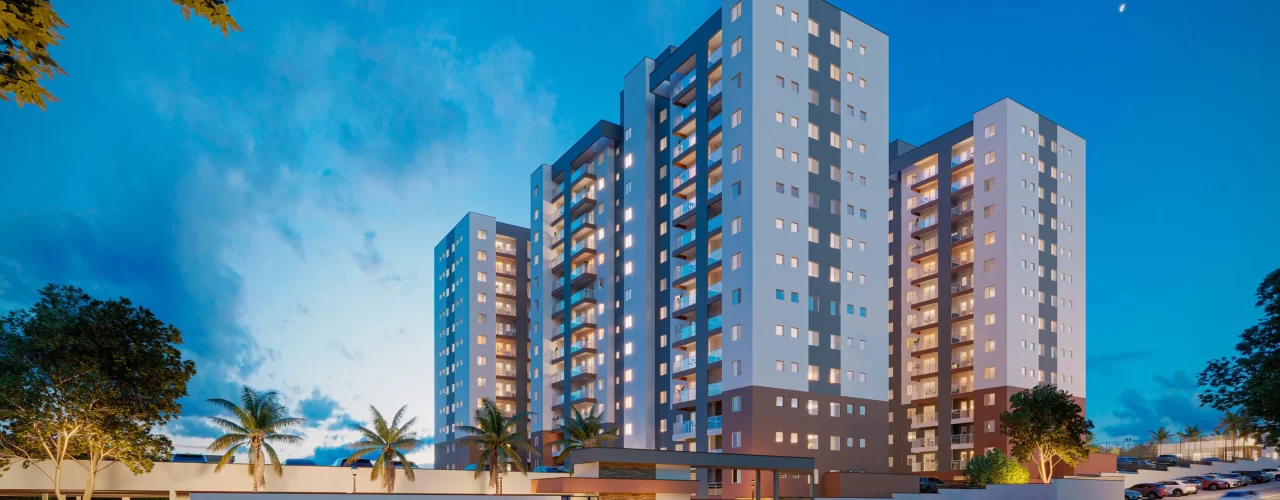 Fachada de condomínio residencial moderno com torres altas iluminadas ao anoitecer, transmitindo sensação de segurança e sofisticação.